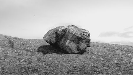 Big boulder on a beach in the center of the frame