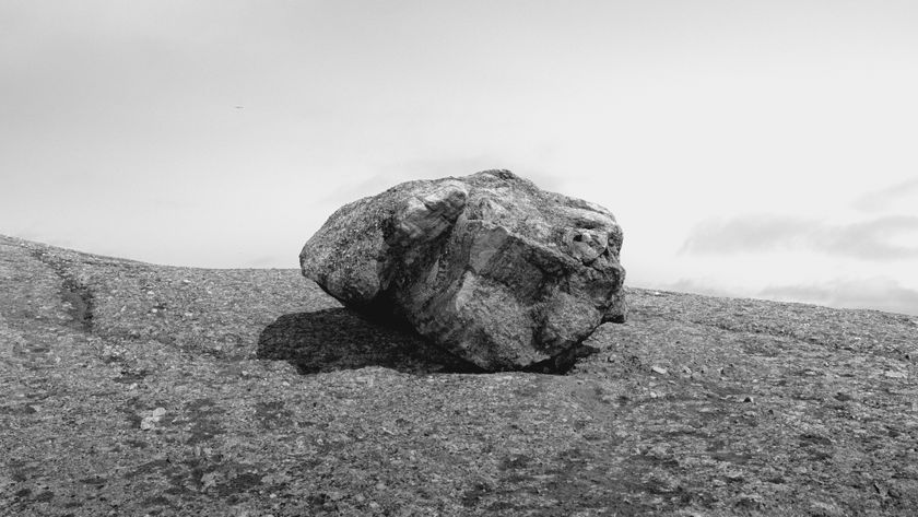 Big boulder on a beach in the center of the frame
