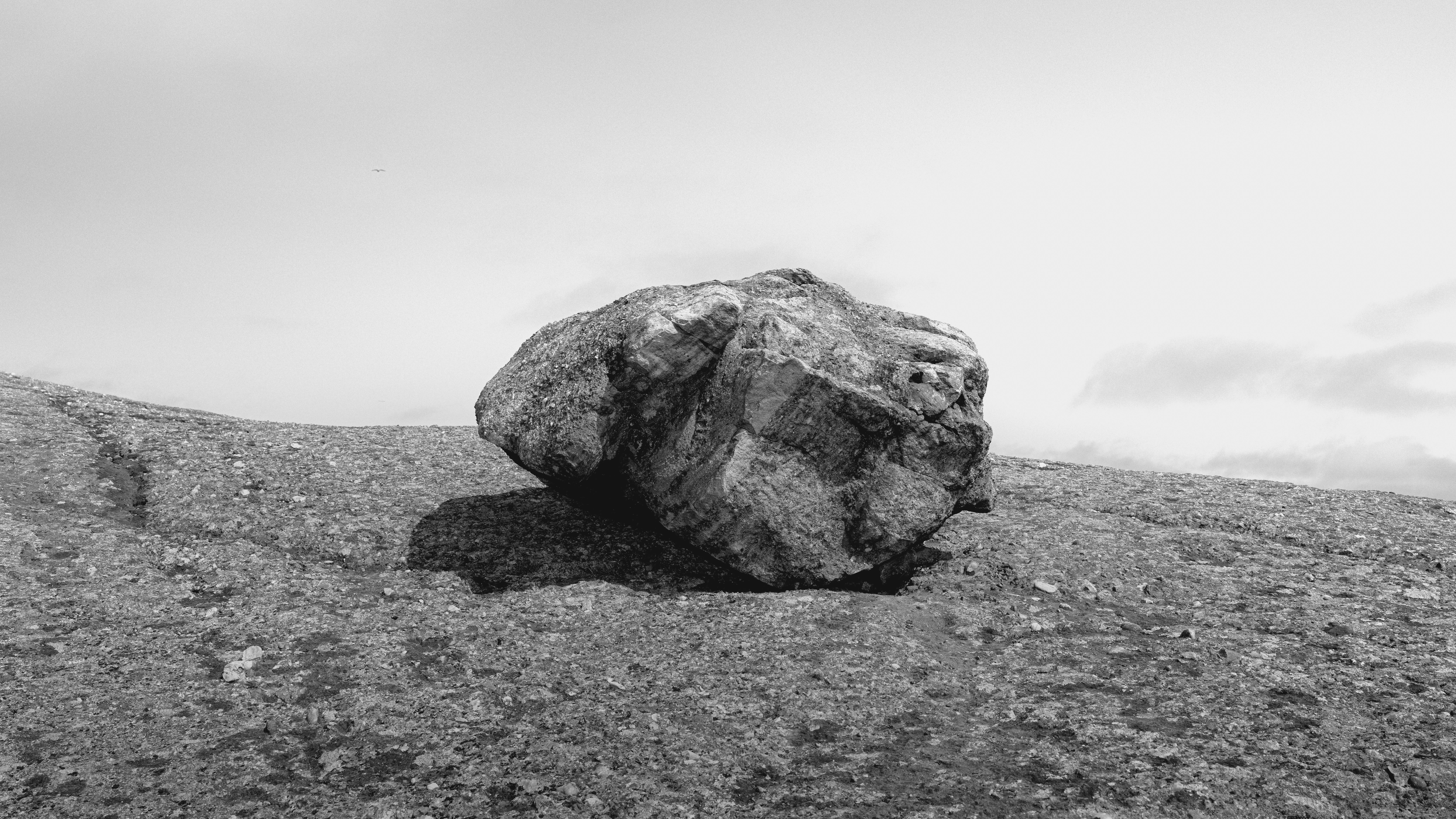 Big boulder on a beach in the center of the frame
