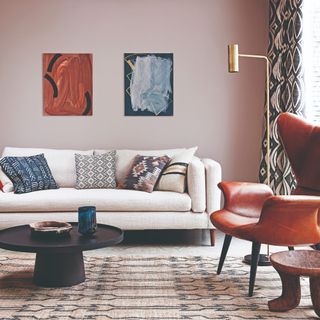 A living room with pink walls and a brass floor lamp