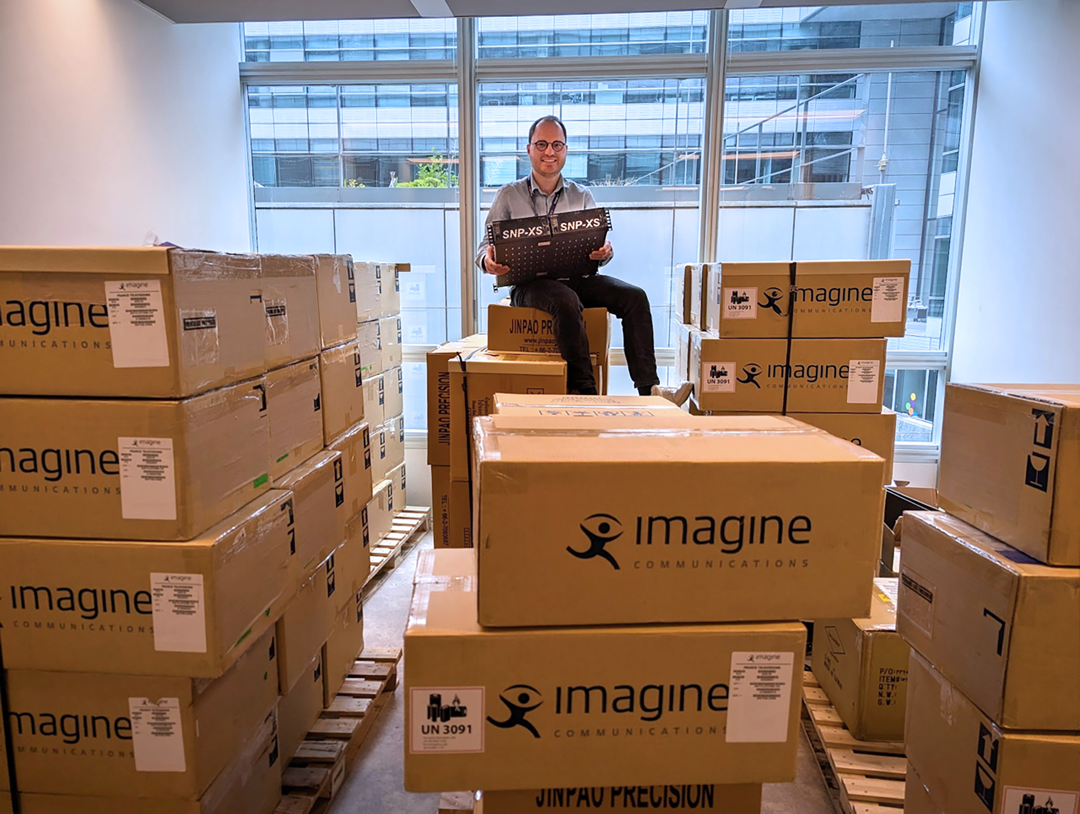 Yannick Olivier of France T&eacute;l&eacute;visions sits atop a newly delivered batch of Imagine SNP&ndash;XS units, highlighting the broadcaster&rsquo;s large&ndash;scale deployment.