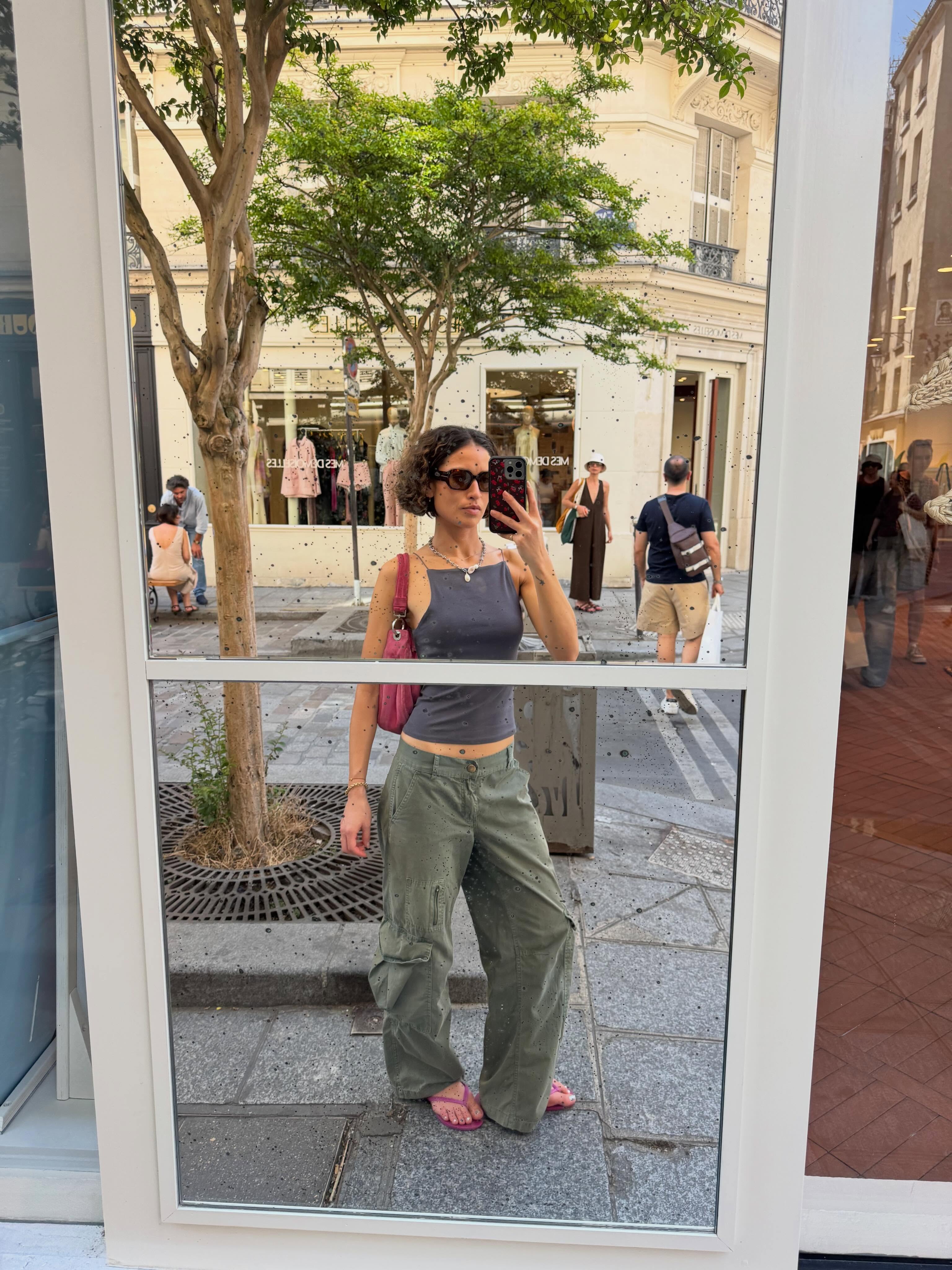 Influencer Caitlin Miyako wearing a tank top, cargo trousers, flip flops and shoulder bag.