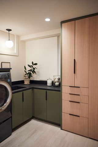 Laundry room with dark green cabinetry