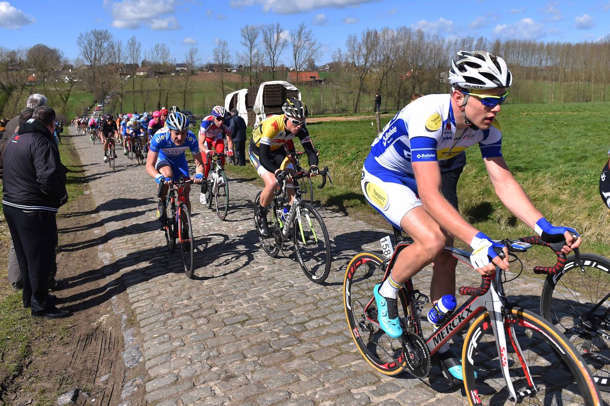 The peloton goes over the cobbles