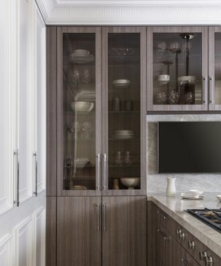 A kitchen with grey oak veneer glass-fronted cabinets and a breakfast bar