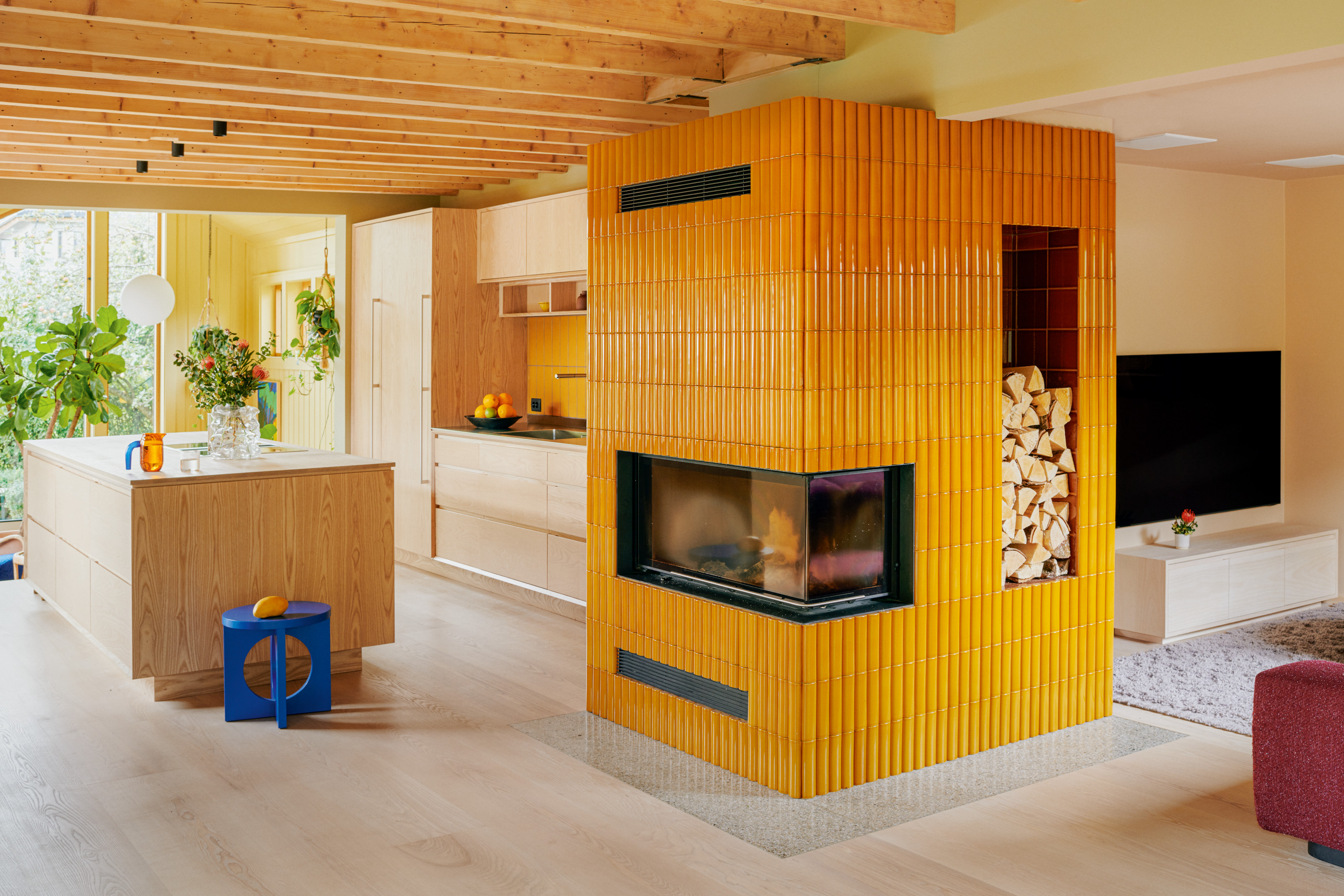 Ash kitchen with corner fireplace covered in mustard yellow tiles
