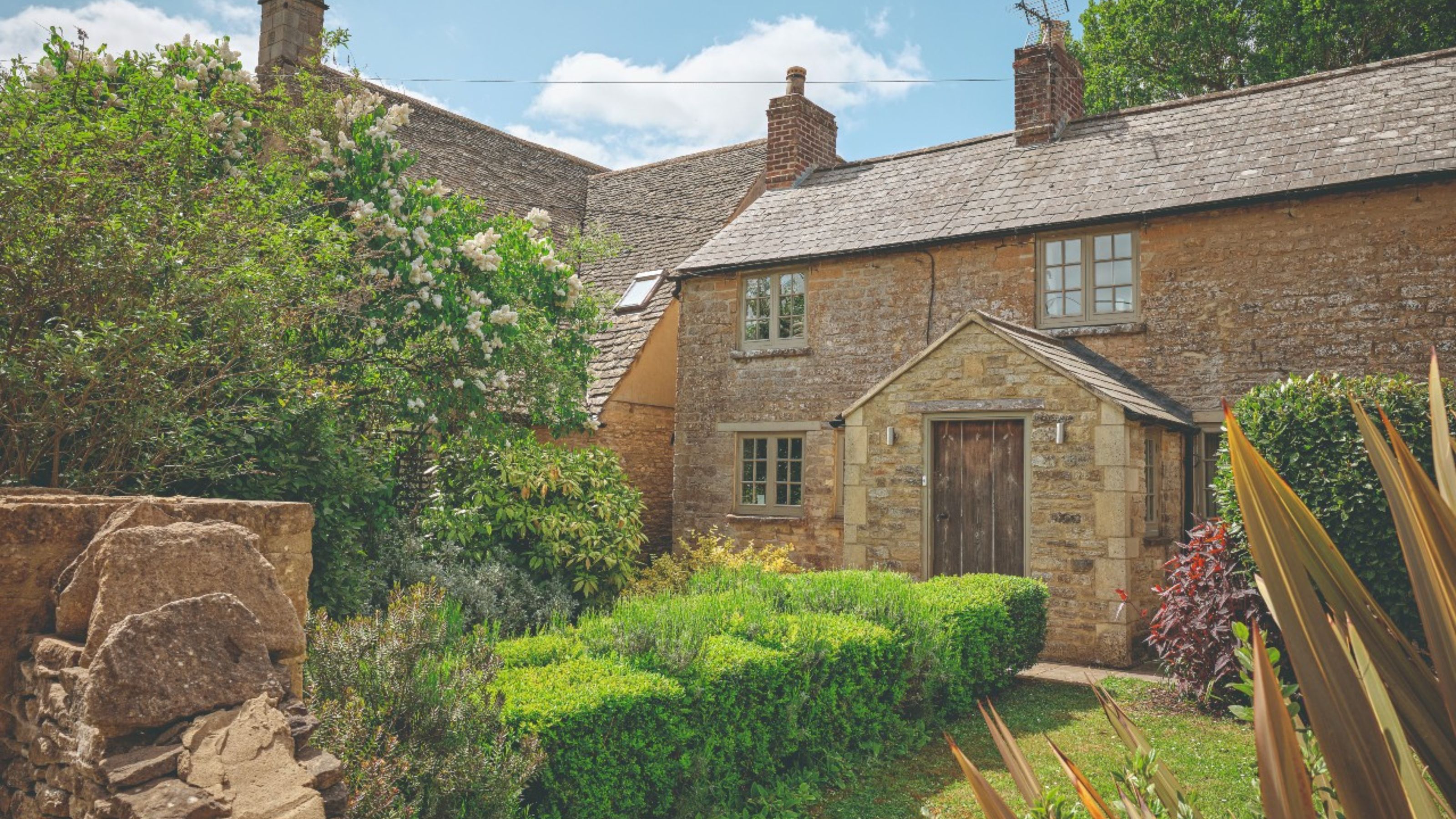Wide angle view of the exterior of a cottage in the Cotswolds, owned by the Clacks family