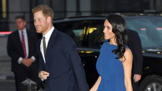 Prince Harry and Meghan Markle arriving at an event dressed in evening wear.