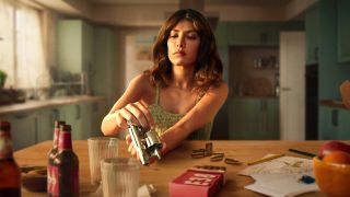 A woman empties a pistol on a table in Netflix's Who Is Erin Carter? TV series
