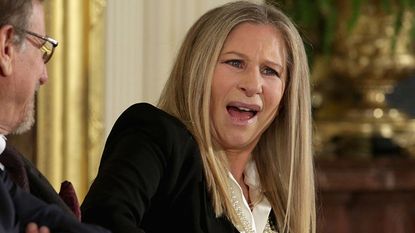 Barbra Streisand reacts to the words President Barack Obama said about her before presenting her with the Presidential Medal of Freedom during a ceremony in the East Room of the White House on Nov. 24, 2015.