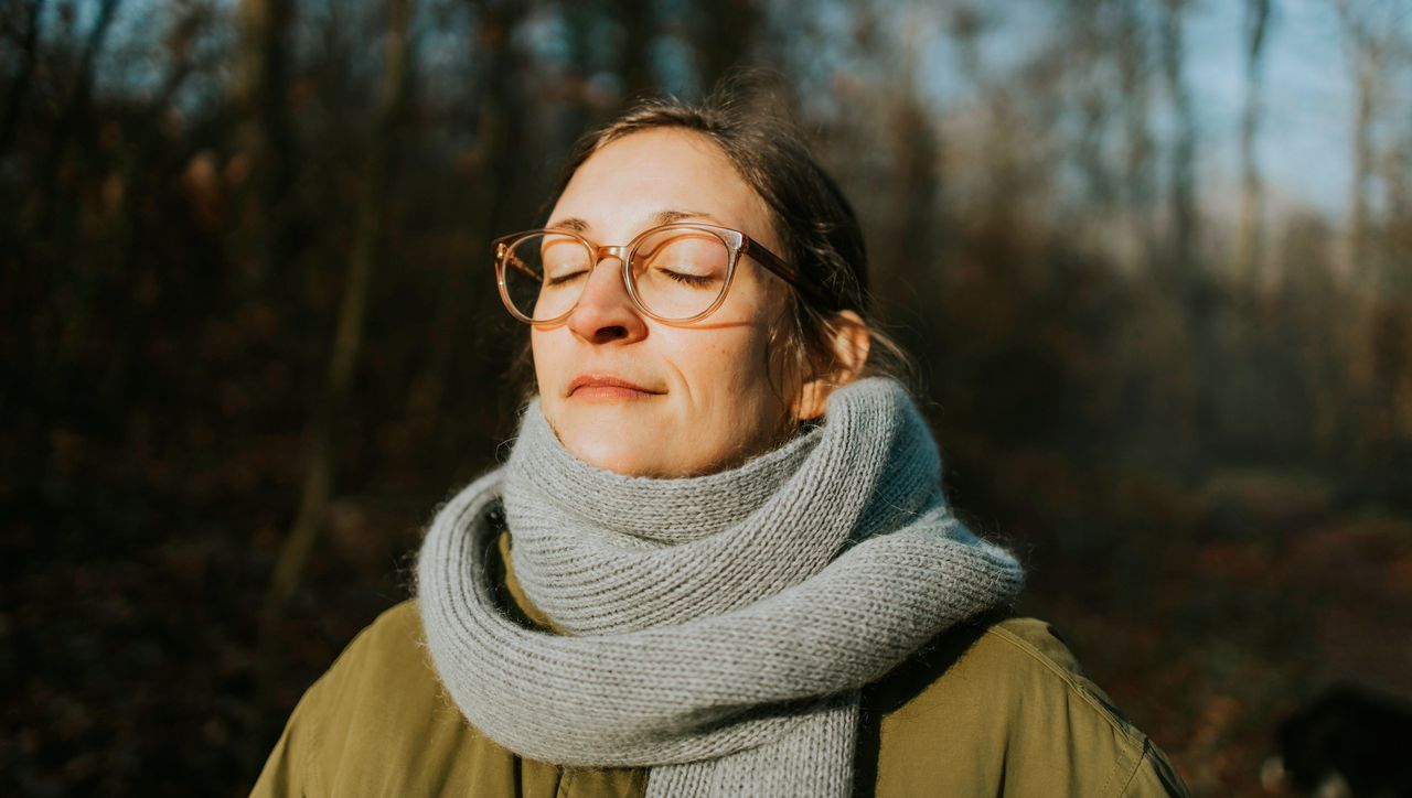 Woman standing outside with eyes closed