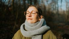 Woman standing outside with eyes closed