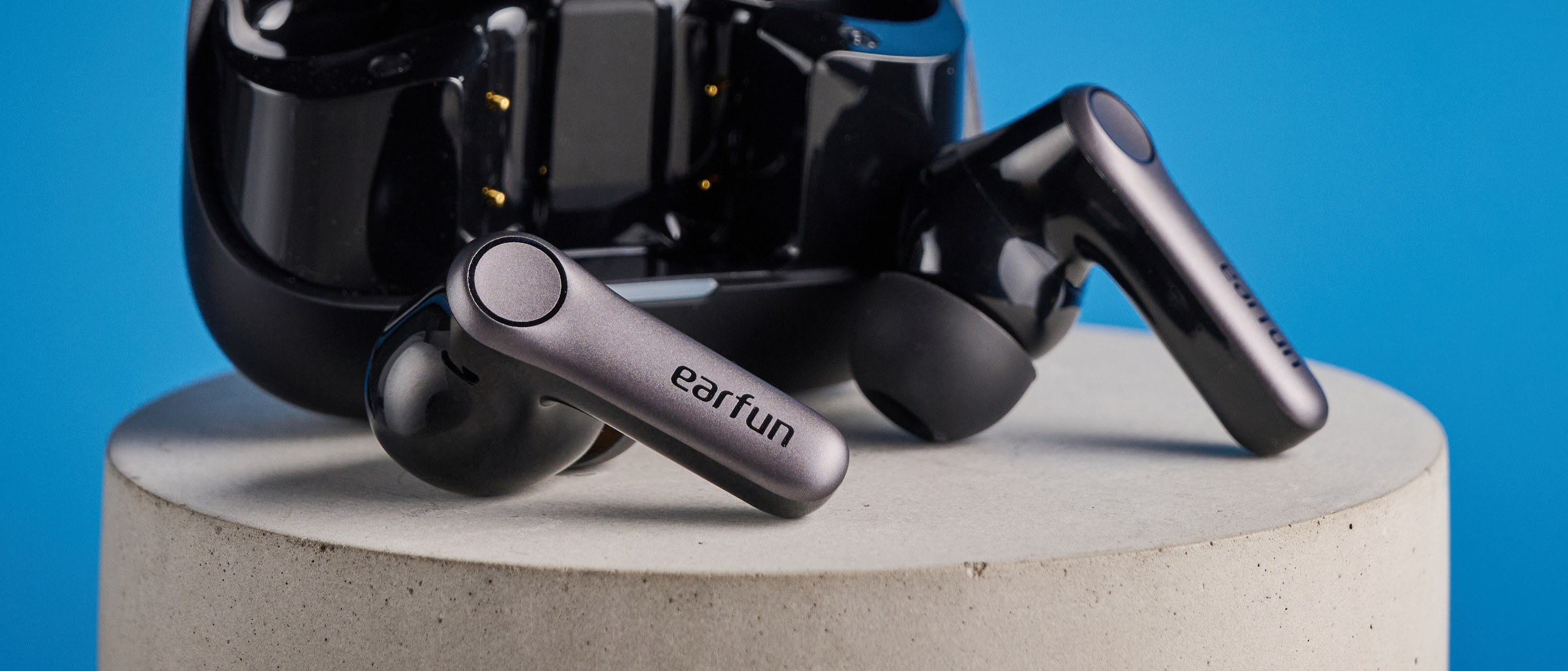 the earfun air pro 4+ earbuds in black showing the ear tips, charging case, and being worn