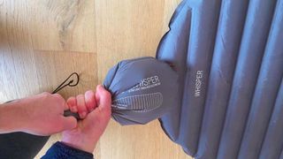 Alpkit Whisper sleeping mat being inflated with a pump sack