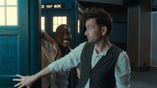 Ncuti Gatwa smiling at David Tennant as he looks into the TARDIS.