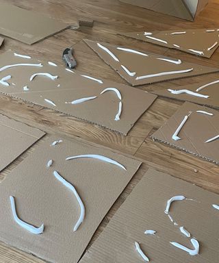 Squiggles of white glue on cardboard shapes cut out for my DIY coffee table project