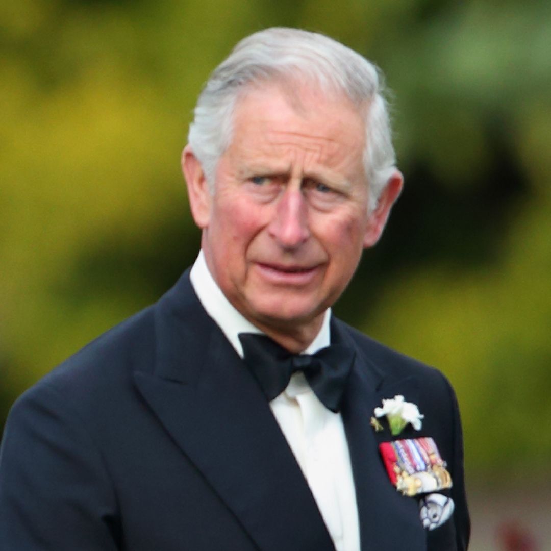 Prince Harry wears a suit with military medals and points while dad King Charles looks on while wearing a tuxedo