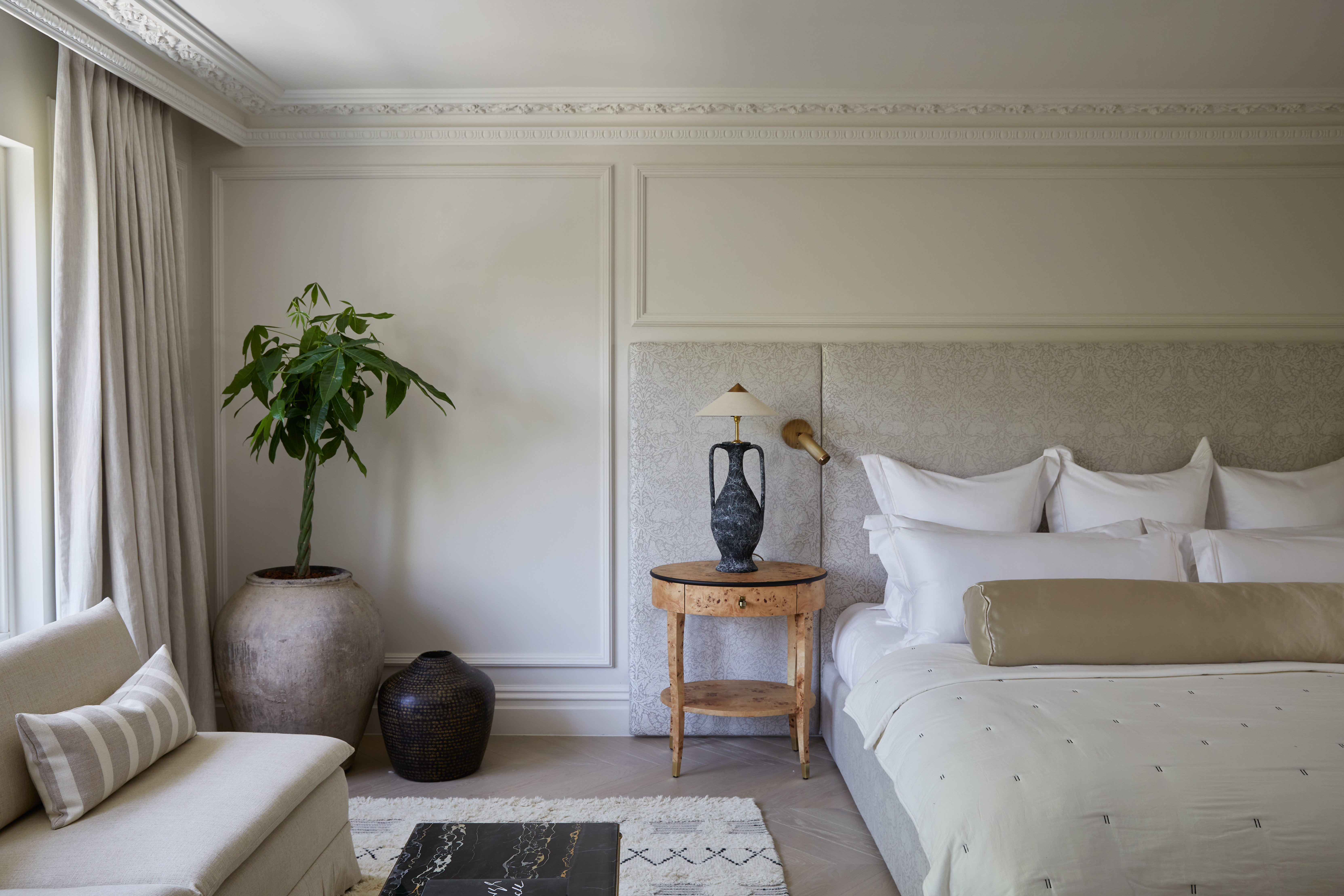 neutra; bedroom with antique accents, including a bedside lamp and terracotta plant pot
