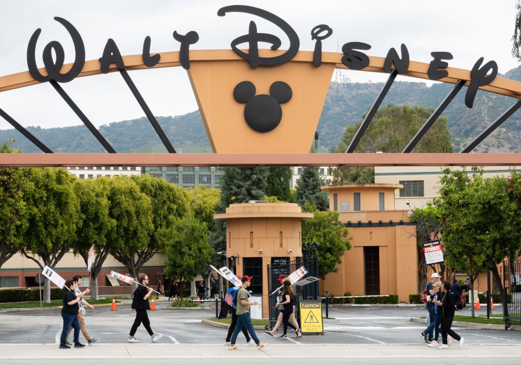 Picketers walk in front of Walt Disney Studios.