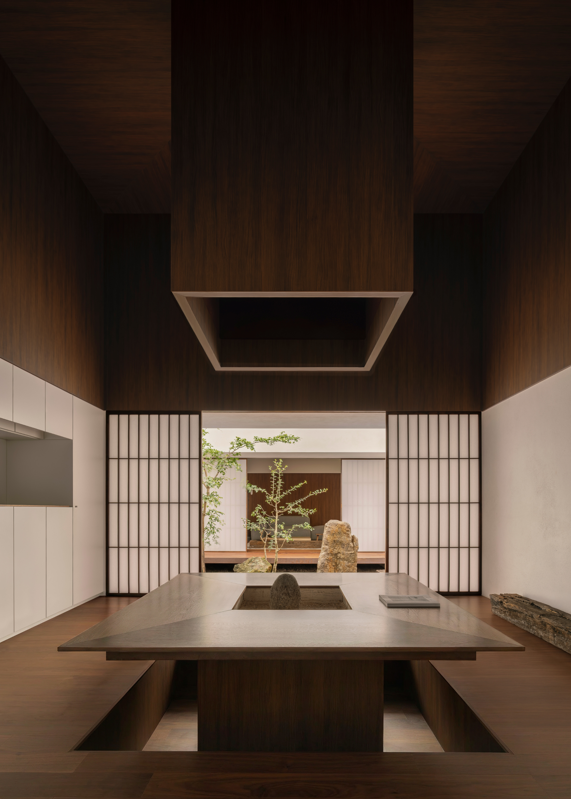 A Japanese kitchenette and dining room with a sunken seating space, and paper doors leading to a garden