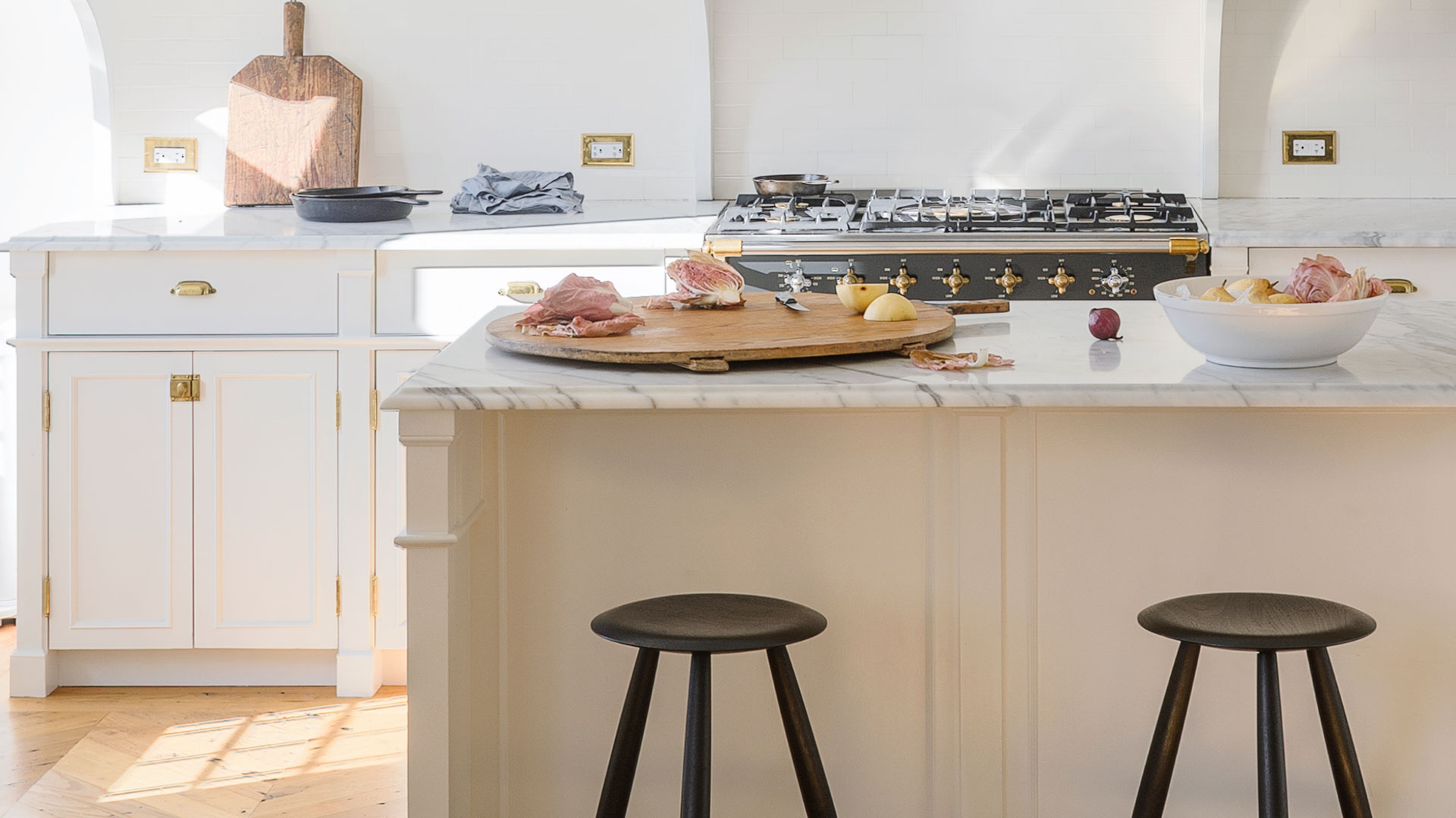 Elegant white kitchen with Shaker cabinets and marble worktops and a kitchen island