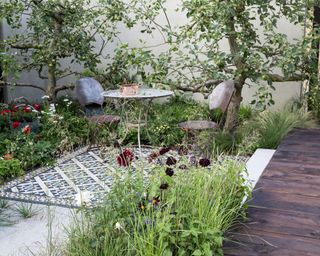 courtyard garden with wooden deck, tiled area and planting
