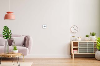 smart thermostat in a modern living room on a white wall
