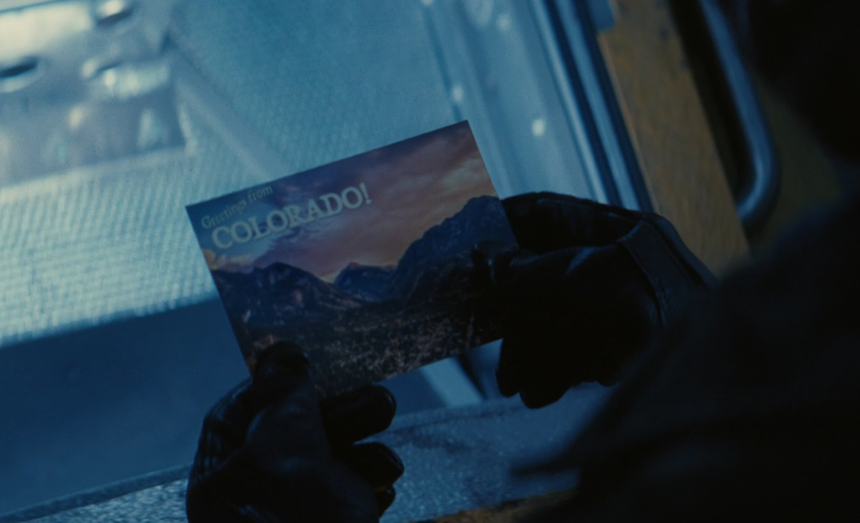 Ghoul holding a Colorado postcard