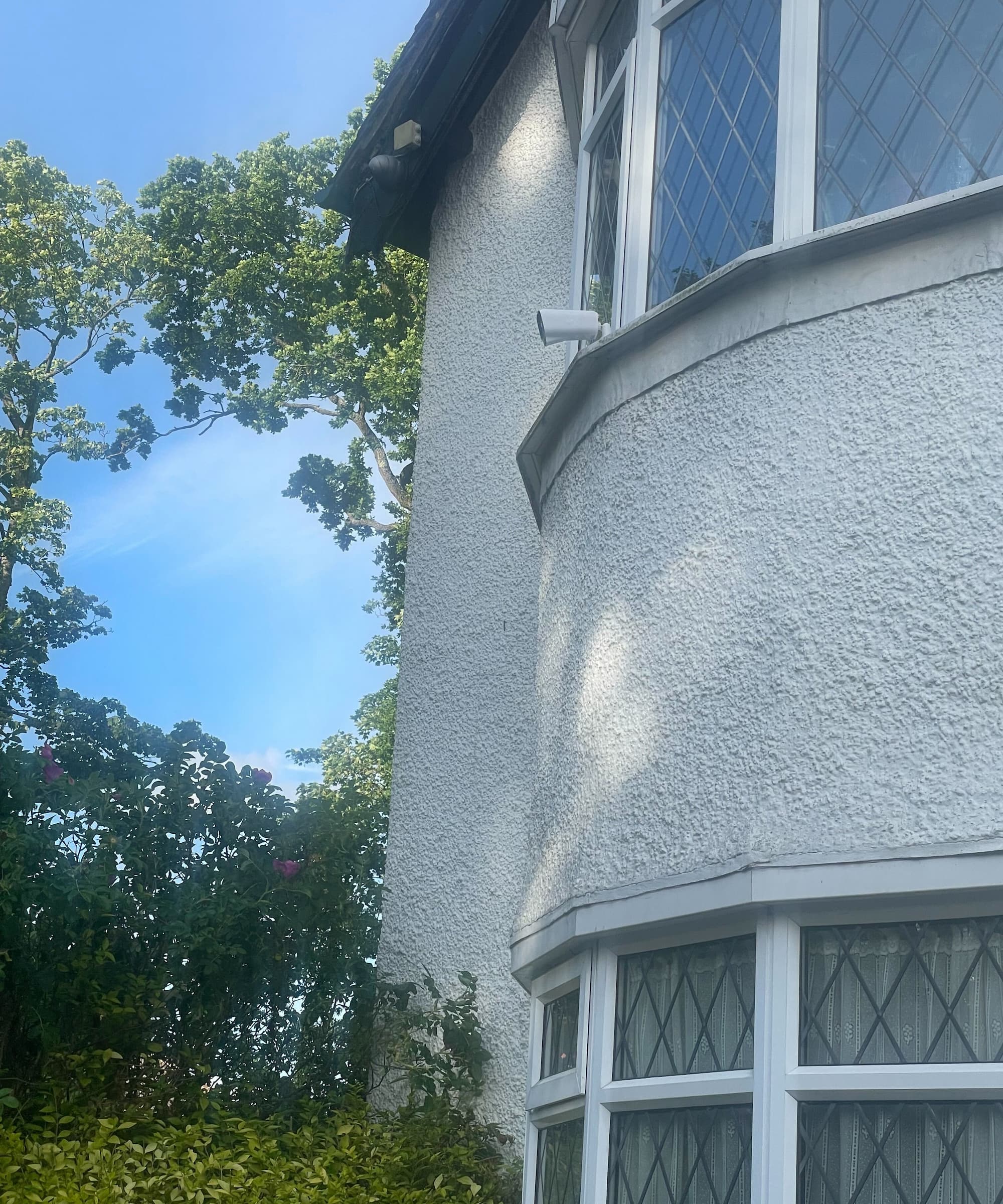 A camera seen from a driveway on a windowsill