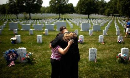 Mourners stand at a grave in Arlington.