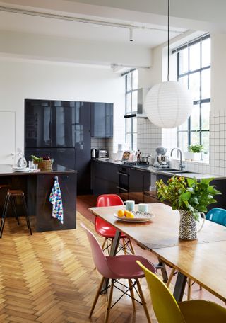 Carlo Viscione: industrial-style kitchen with dark blue units, parquet flooring and grid-pattern white splashback tiles