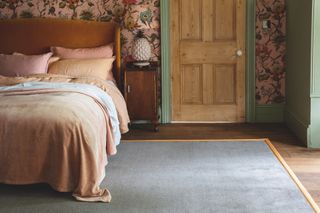bedroom with wooden floor floral wallpaper and grey carpet