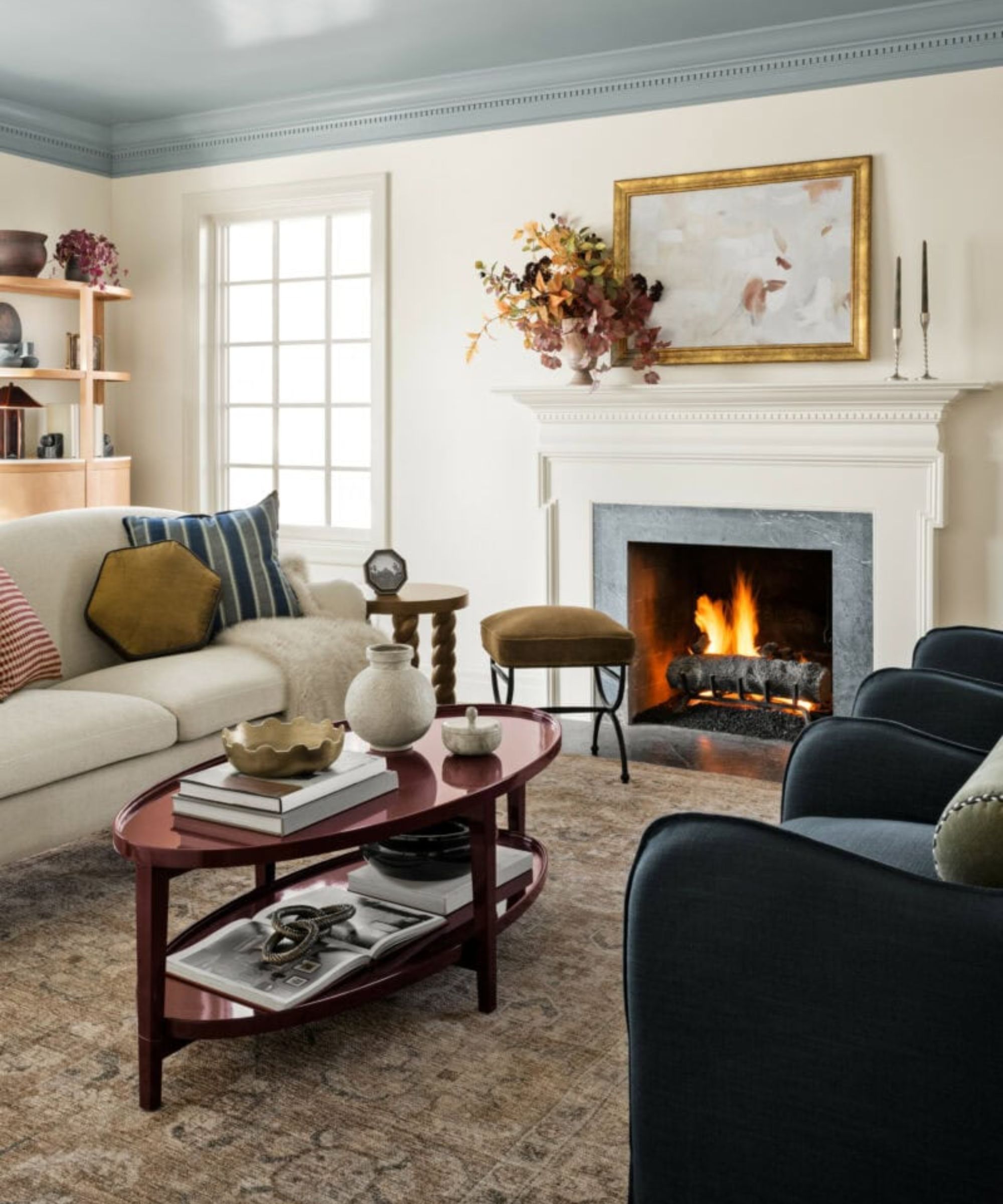 traditional cozy living room by shea mcgee for target with a blue glossy painted ceiling and a lacquered dark red coffee table