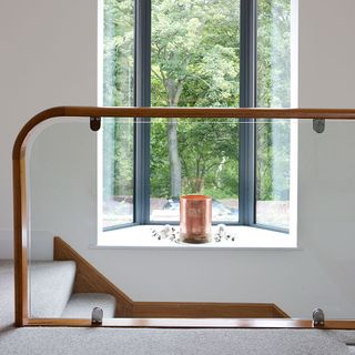 Wooden banister on staircase with glass panel