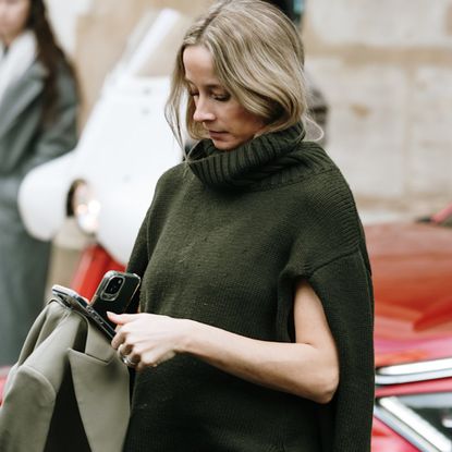 Woman wearing a green sweater vest in Paris. 