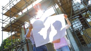 Couple looking at plans on building site