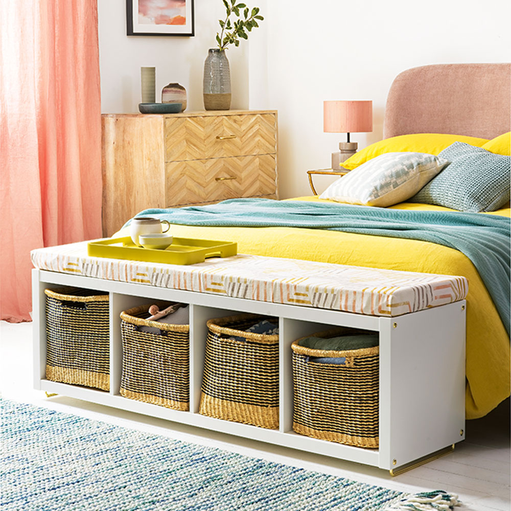 white bedroom with yellow bed and baskets