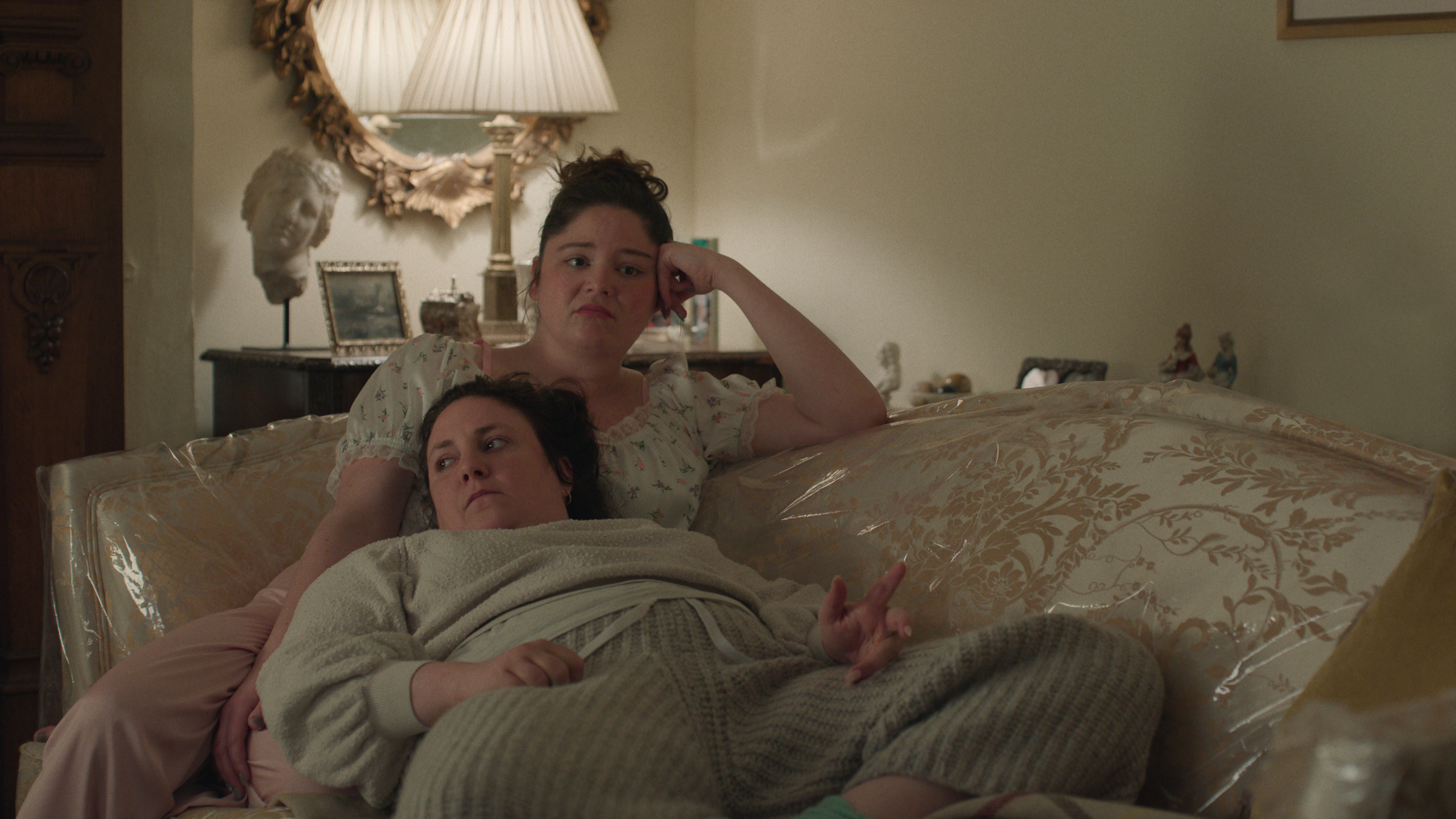 Jess and Nora lying on a sofa in Too Much