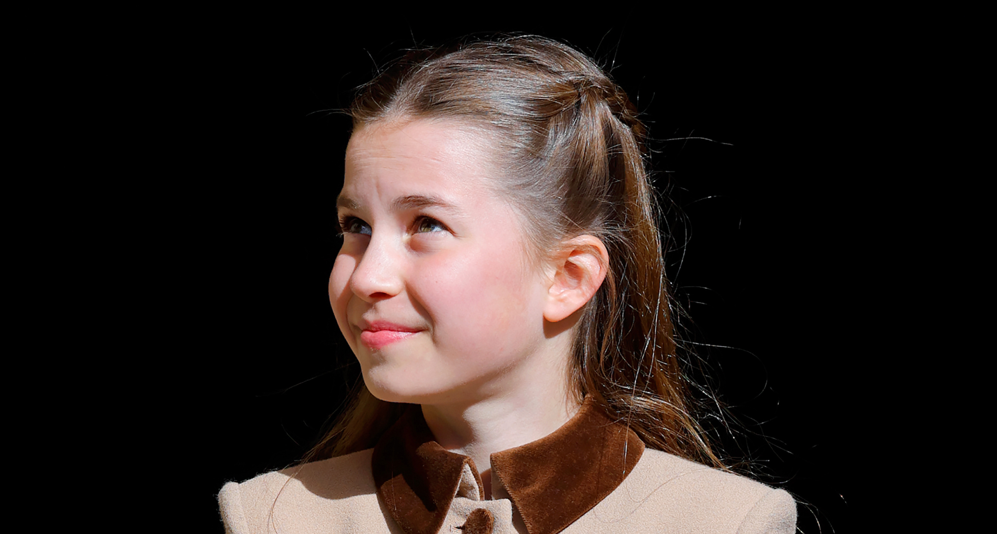 Princess Charlotte wearing a brown coat and smiling