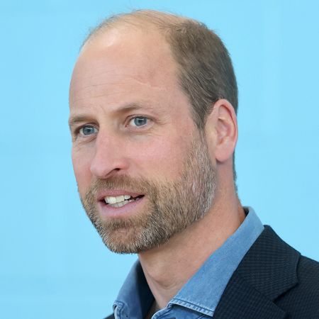 A headshot of Prince William smiling in a blue shirt