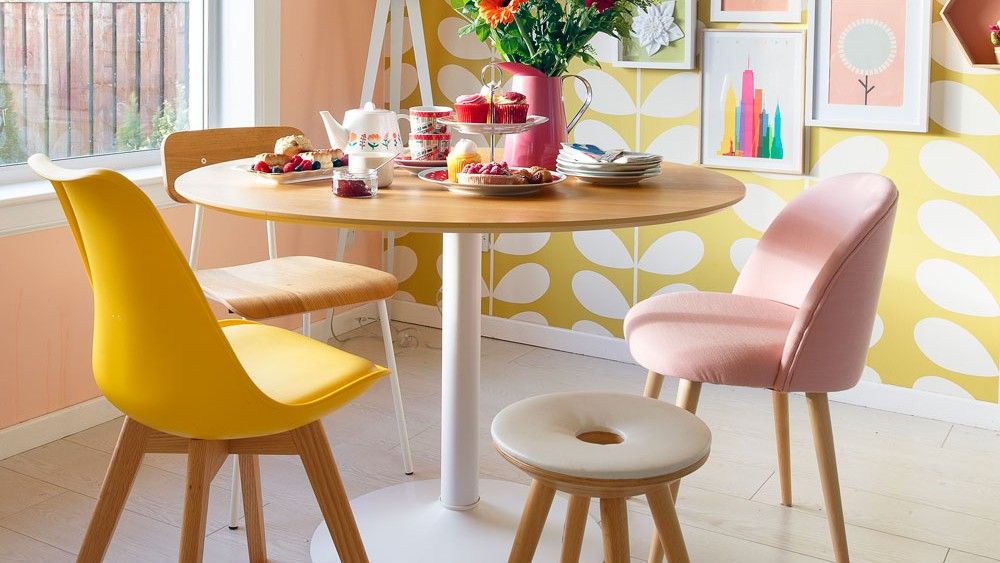 dining area with wooden flooring and nulticolour walls and round dining table with multicolour chairs