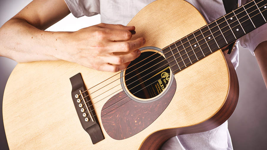 Man playing a Martin LX1E