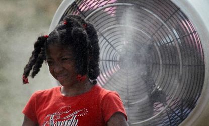 Kierra Waller, a 9-year-old girl from Baltimore, tries to beat the heat with a misting fan during an NFL football training camp practice in Virginia.