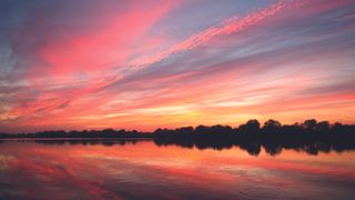 Golden hour photography image of a blue, pink and yellow sky, reflected in a body of water