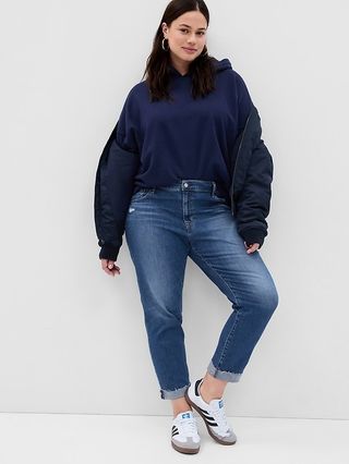 gap model in dark wash jeans, sweatshirt, and adidas sneakers