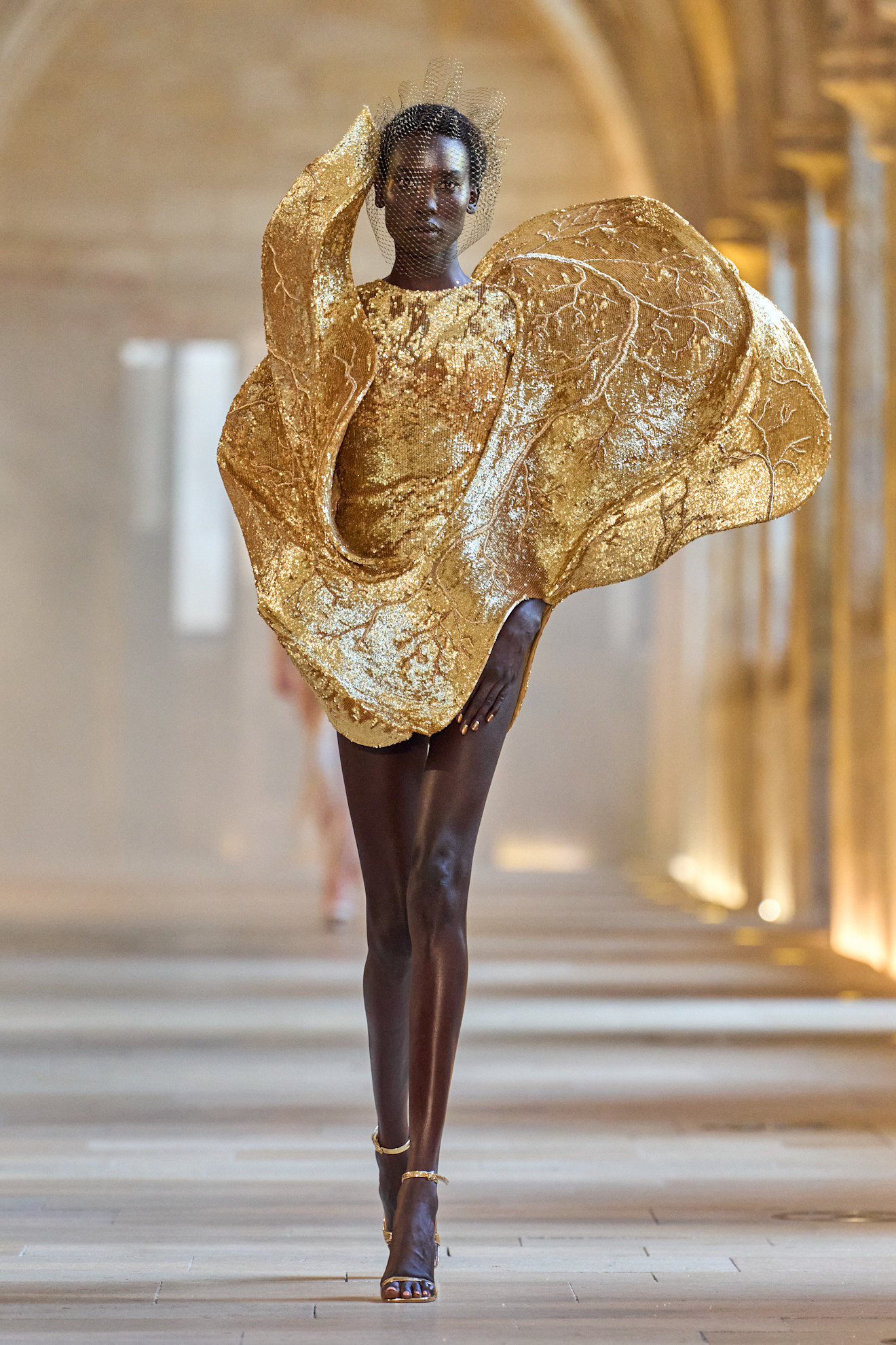 A model wore Olandria Carthen's gold dress during the Rahul Mishra Fall 2025 Couture show