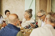 Retirees and younger people dining together at an elegant table. They are either at a senior wedding or have traveled. The location is Morocco.