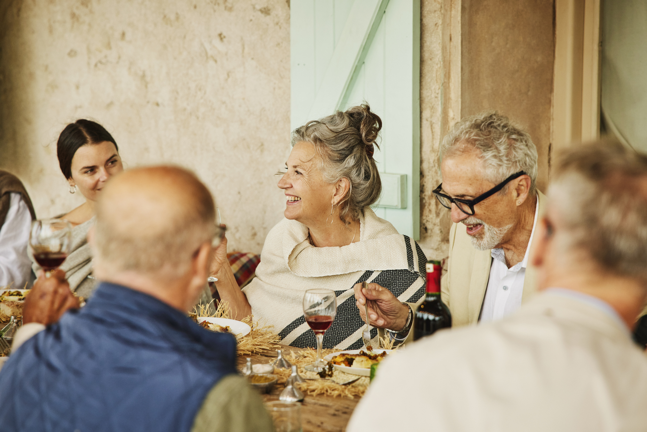 Retirees and younger people dining together at an elegant table. They are either at a senior wedding or have traveled. The location is Morocco.
