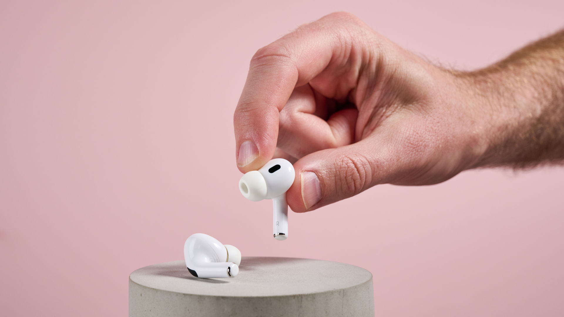 The AirPods Pro 2 earbuds held in a hand