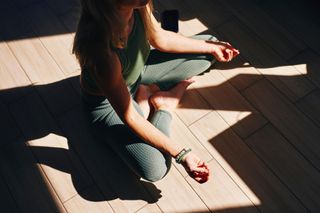 A woman meditating in the sun light.